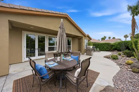 a view of a patio with a table and chairs and potted plants