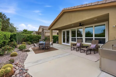a view of a patio with couches and table and chairs with garden and plants