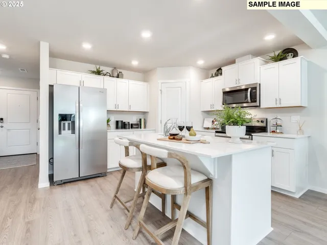 a kitchen with a sink a microwave a refrigerator and cabinets