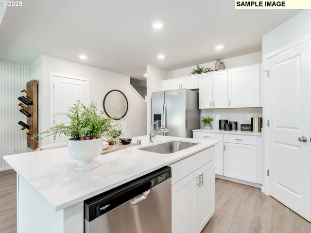 a kitchen with white cabinets a sink dishwasher and a stove with wooden floor