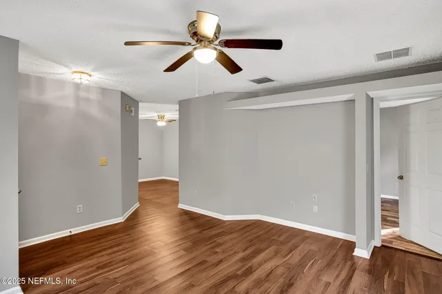 a view of empty room with wooden floor
