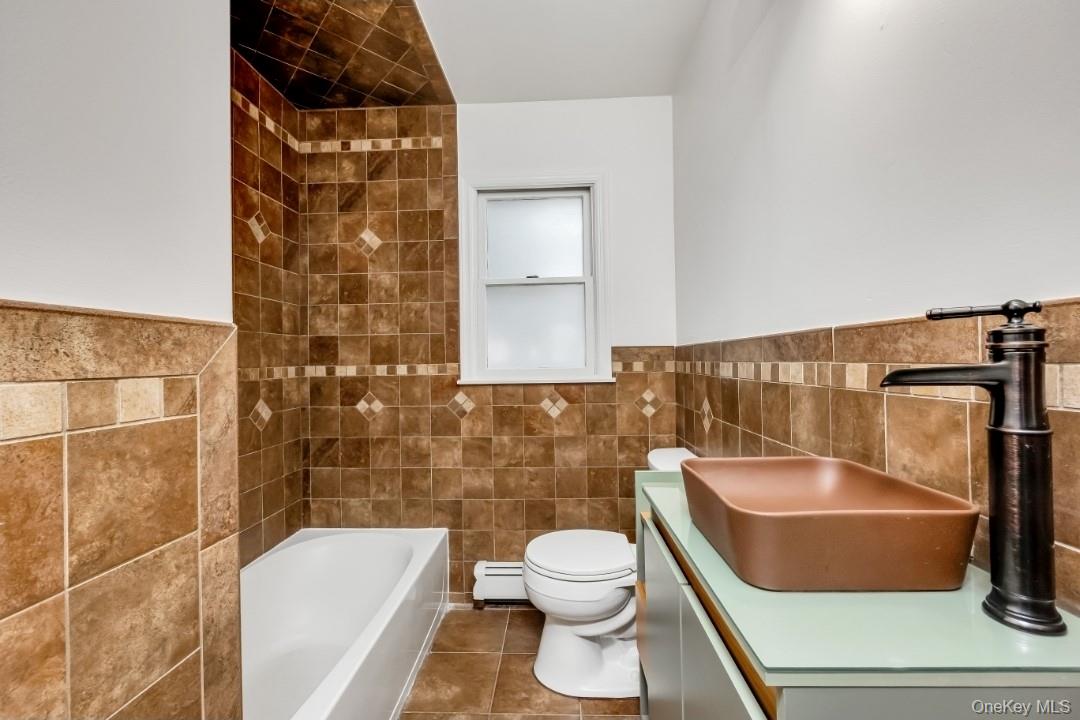 31 Fuller Avenue West Babylon, NY 11704 - Photo 17 of 33 a bathroom with a toilet and a bathtub