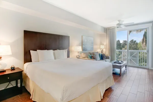 a room with a bed and large windows
