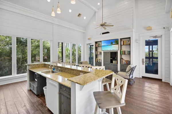 a dining room with furniture large windows and wooden floor