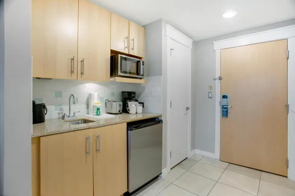 a kitchen with stainless steel appliances granite countertop white cabinets a refrigerator a sink a stove with white cabinets