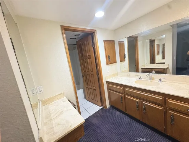 a bathroom with a sink a mirror a vanity and a shower