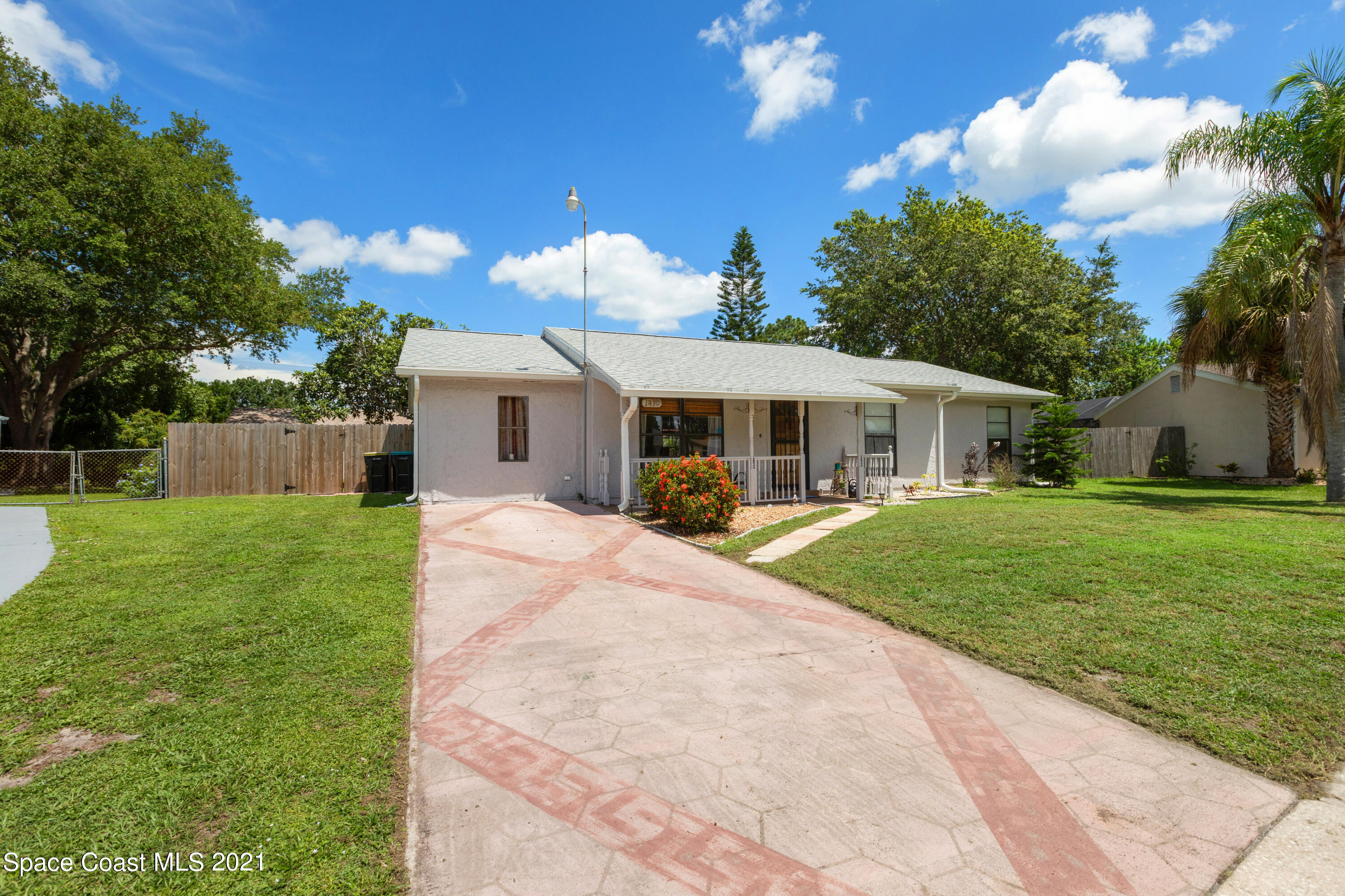 1410 Creel Road Northeast Palm Bay, FL 32905 - Photo 2 of 39 a front view of a house with a yard table and chairs