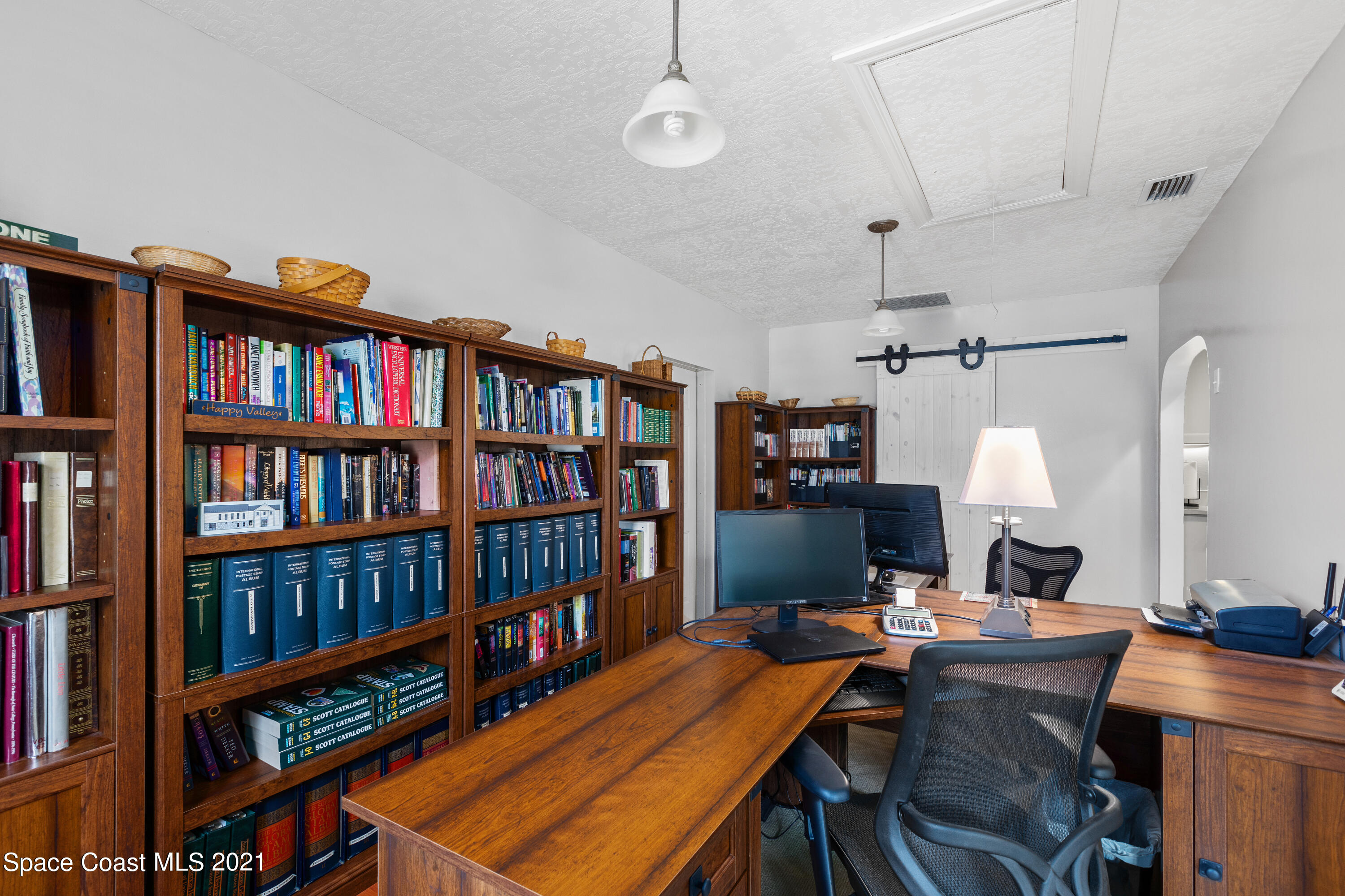 1410 Creel Road Northeast Palm Bay, FL 32905 - Photo 12 of 39 a view of a workspace with furniture and a bookshelf