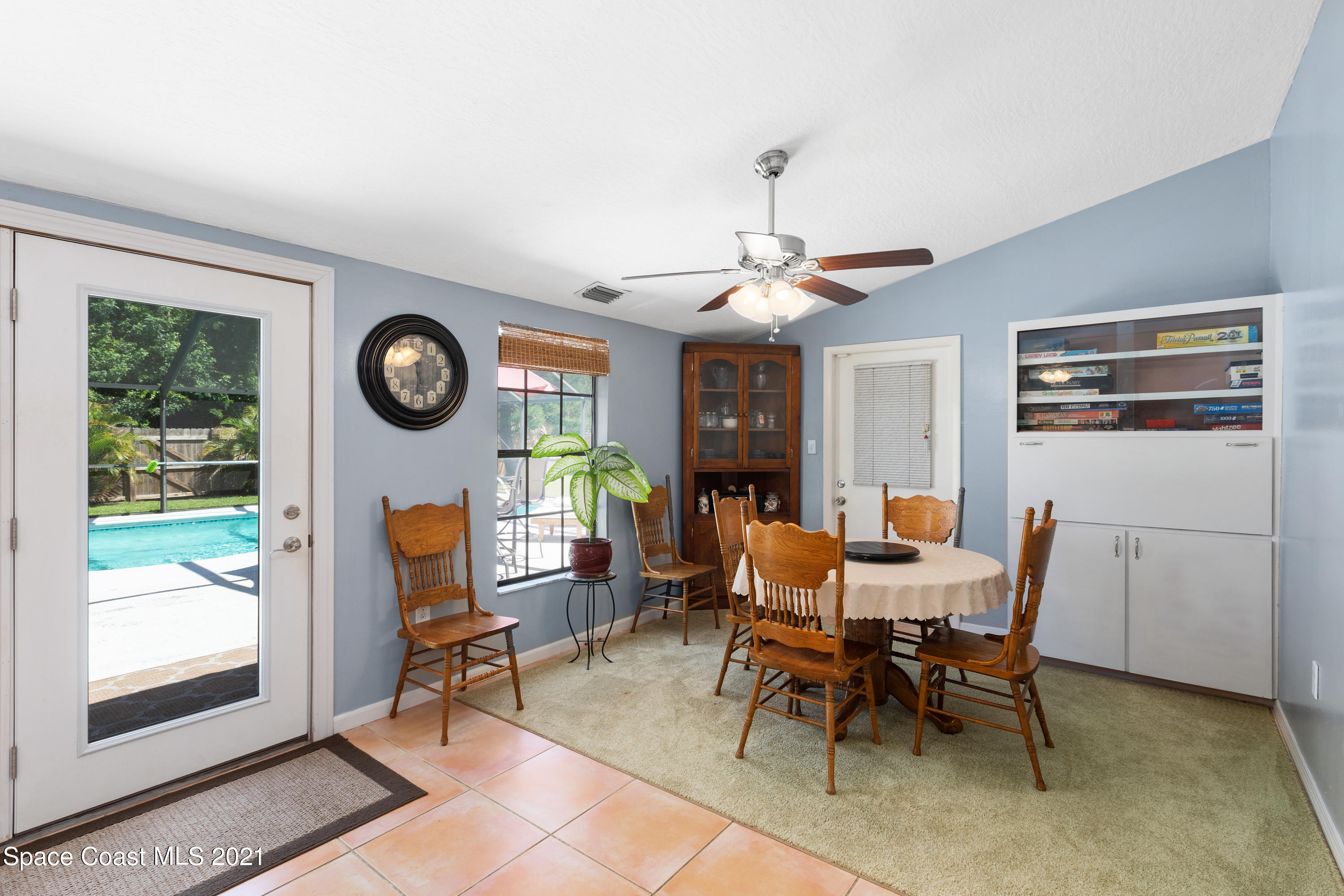 1410 Creel Road Northeast Palm Bay, FL 32905 - Photo 15 of 39 a view of a dining room and livingroom with furniture a rug a fireplace and a large window