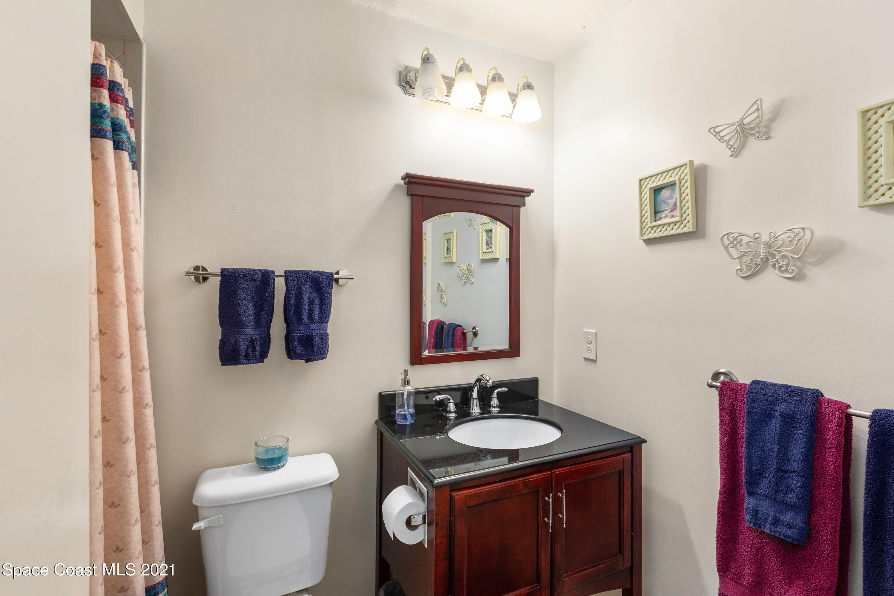 1410 Creel Road Northeast Palm Bay, FL 32905 - Photo 17 of 39 a bathroom with a toilet a sink and mirror