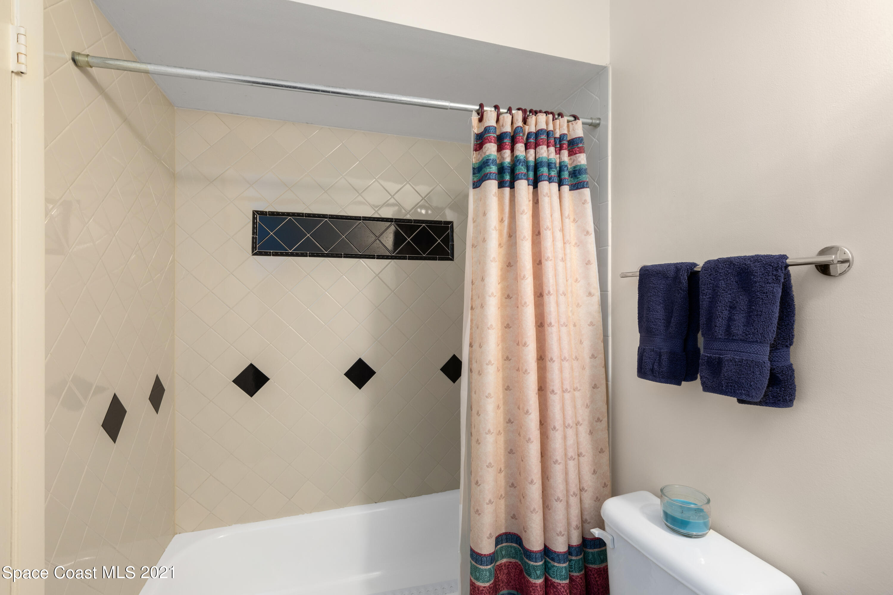 1410 Creel Road Northeast Palm Bay, FL 32905 - Photo 18 of 39 a bathroom with a shower curtain and a window