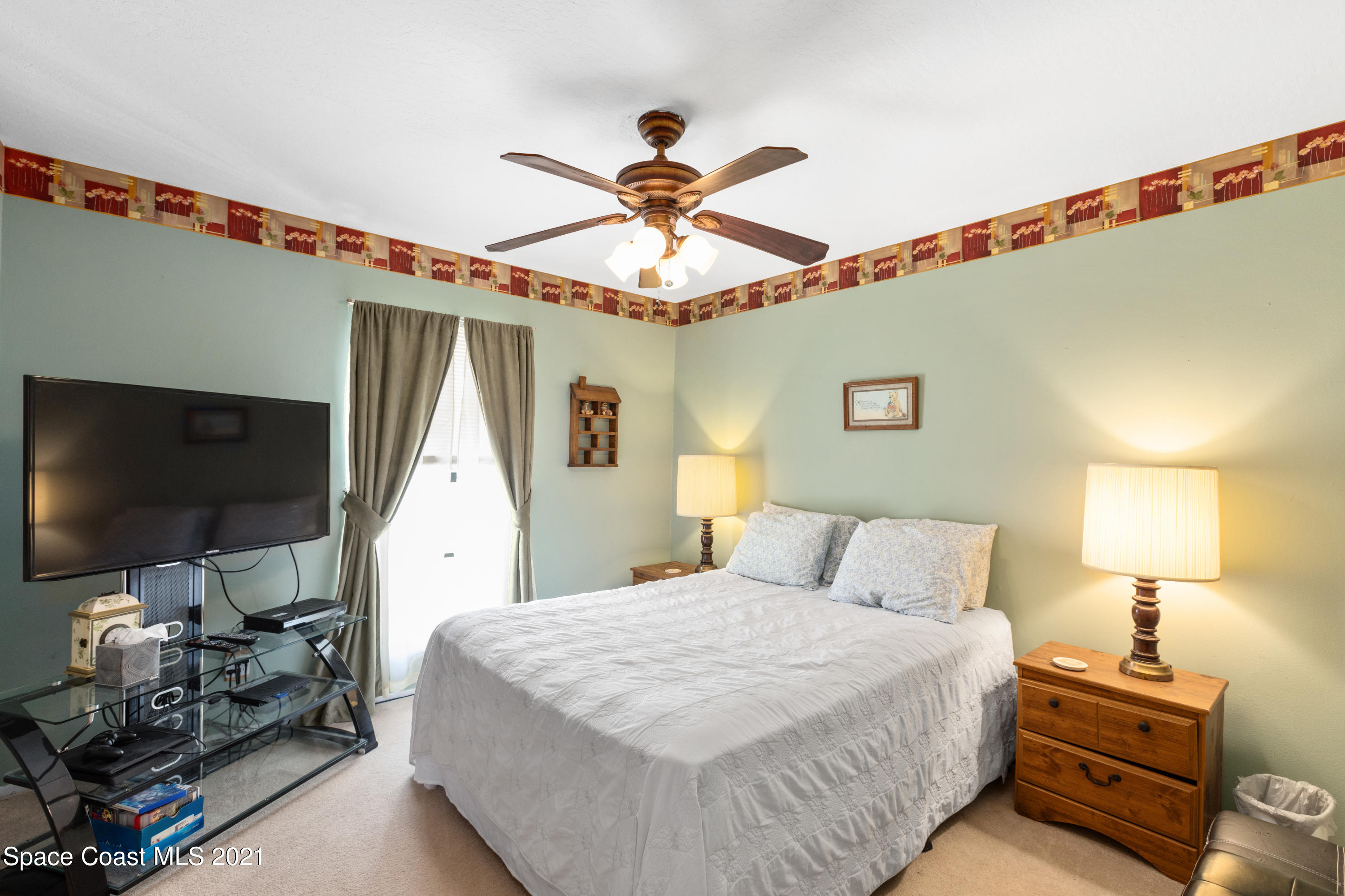1410 Creel Road Northeast Palm Bay, FL 32905 - Photo 19 of 39 a bedroom with a bed and a chandelier