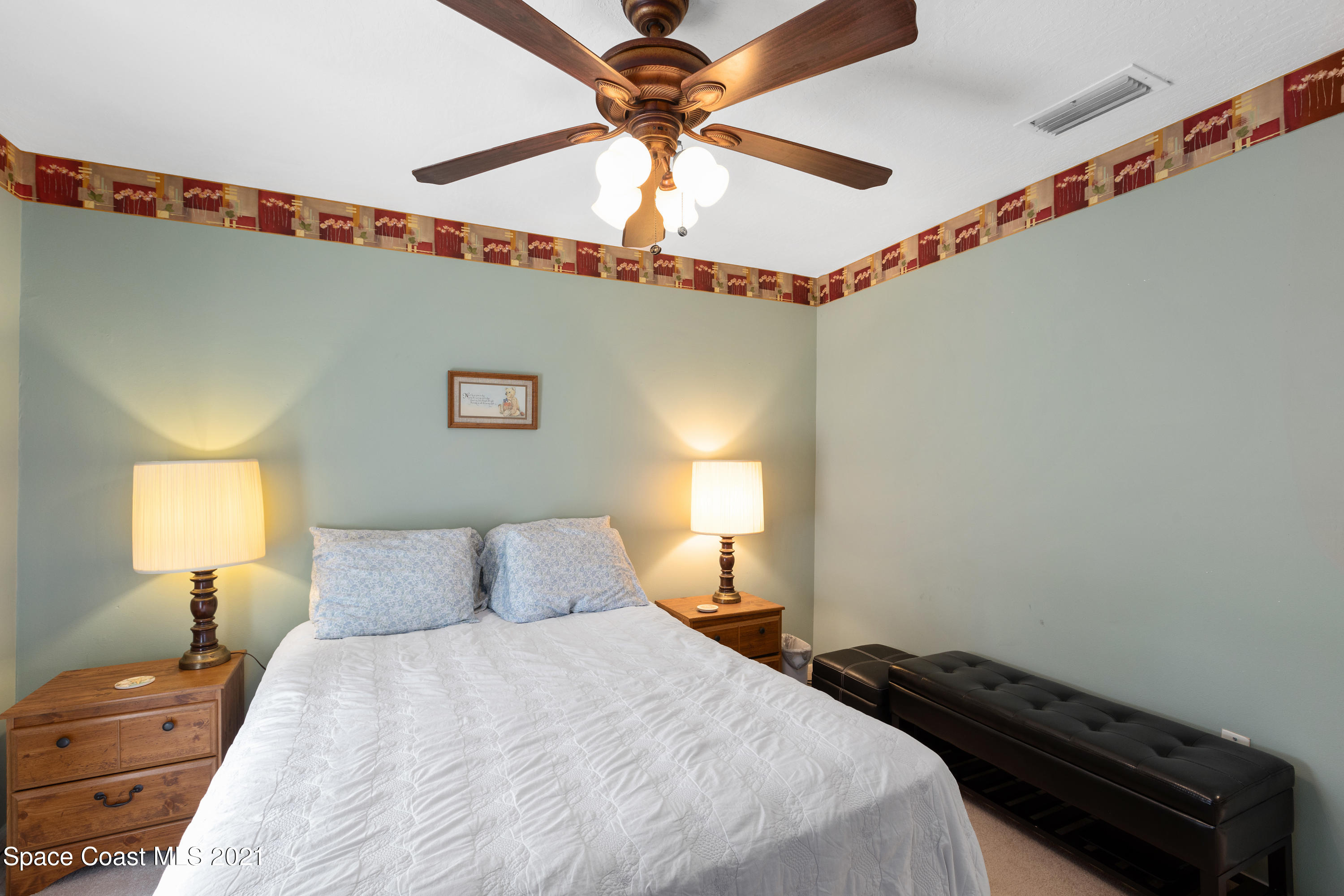 1410 Creel Road Northeast Palm Bay, FL 32905 - Photo 20 of 39 a bedroom with a bed and a chandelier