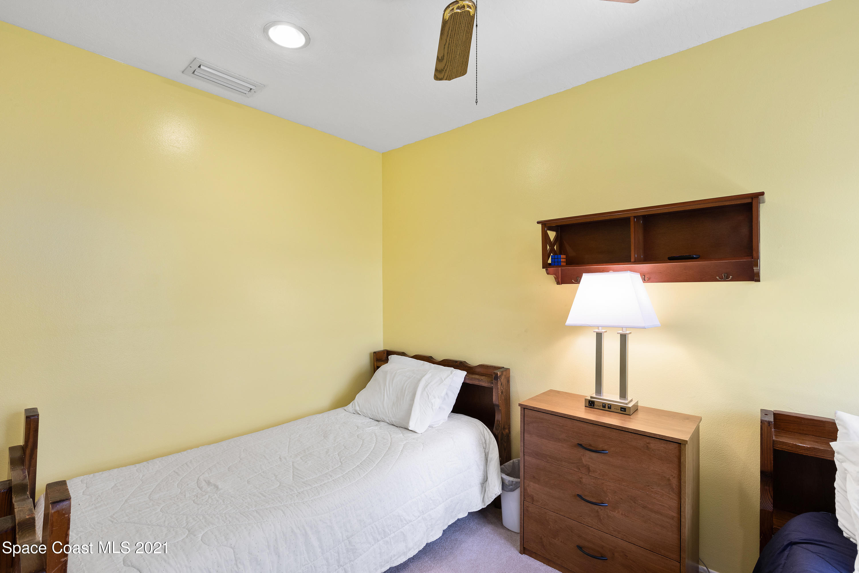 1410 Creel Road Northeast Palm Bay, FL 32905 - Photo 22 of 39 a bedroom with a bed and a lamp on table
