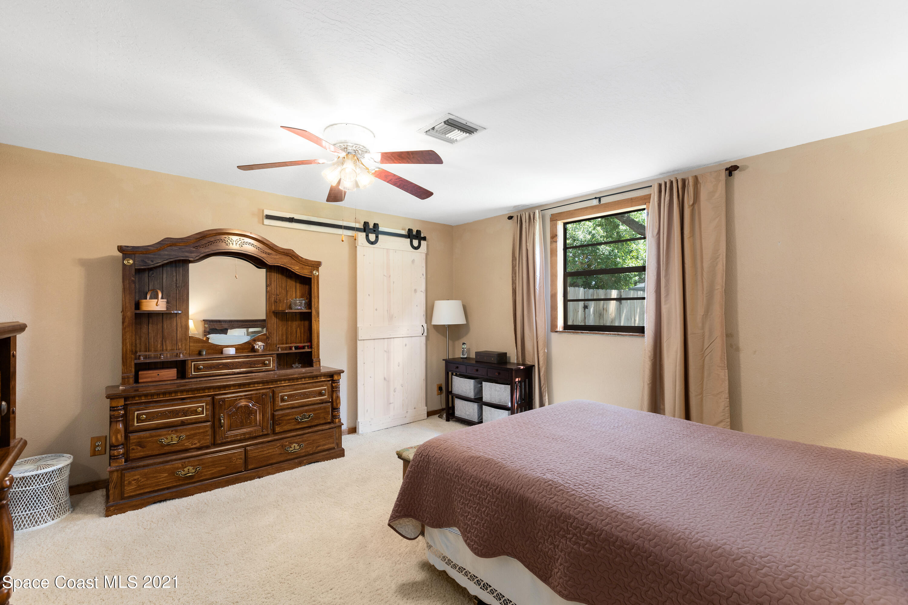 1410 Creel Road Northeast Palm Bay, FL 32905 - Photo 23 of 39 a bedroom with a bed and a chandelier