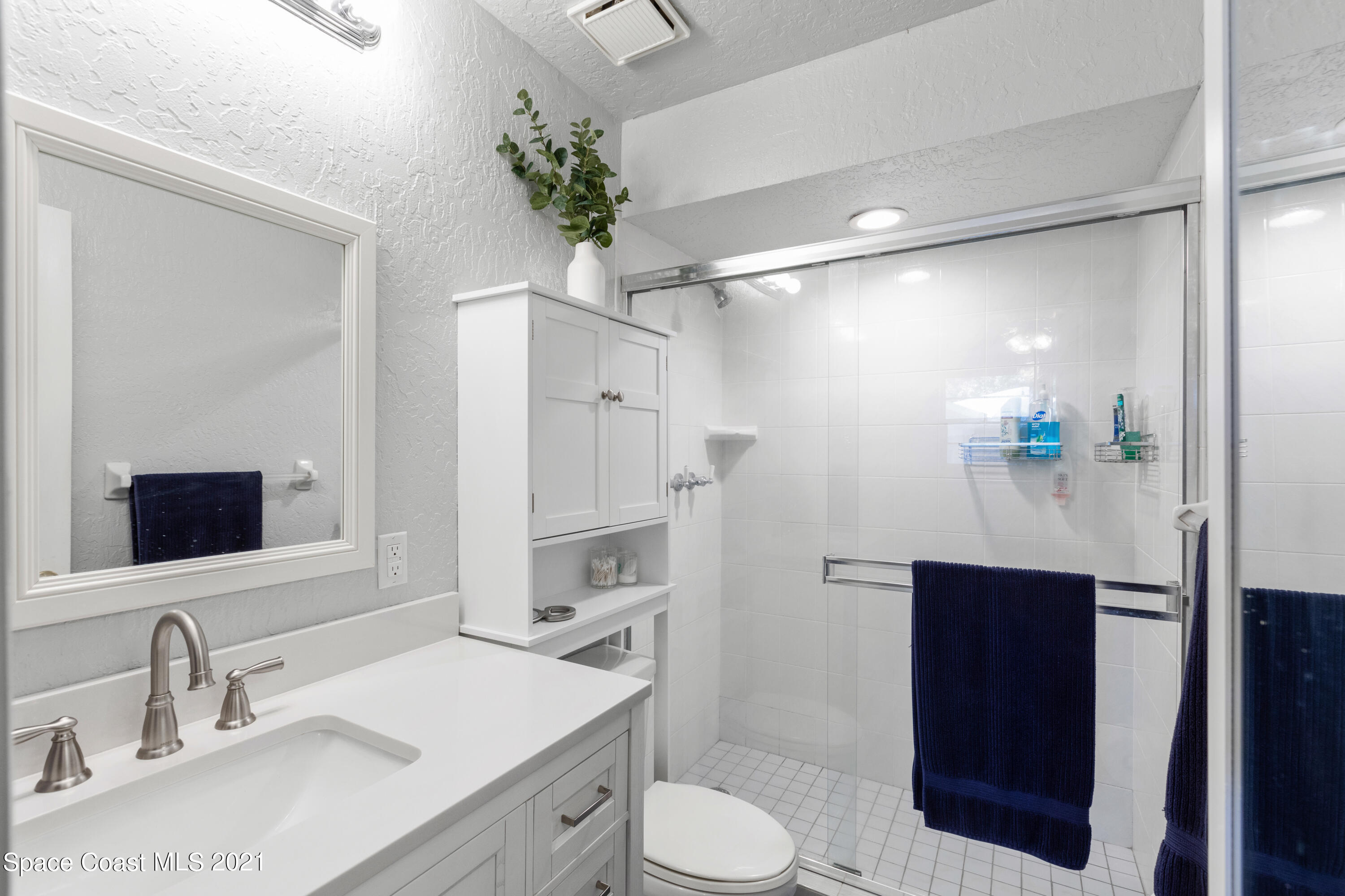 1410 Creel Road Northeast Palm Bay, FL 32905 - Photo 25 of 39 a bathroom with a sink vanity granite toilet and a mirror