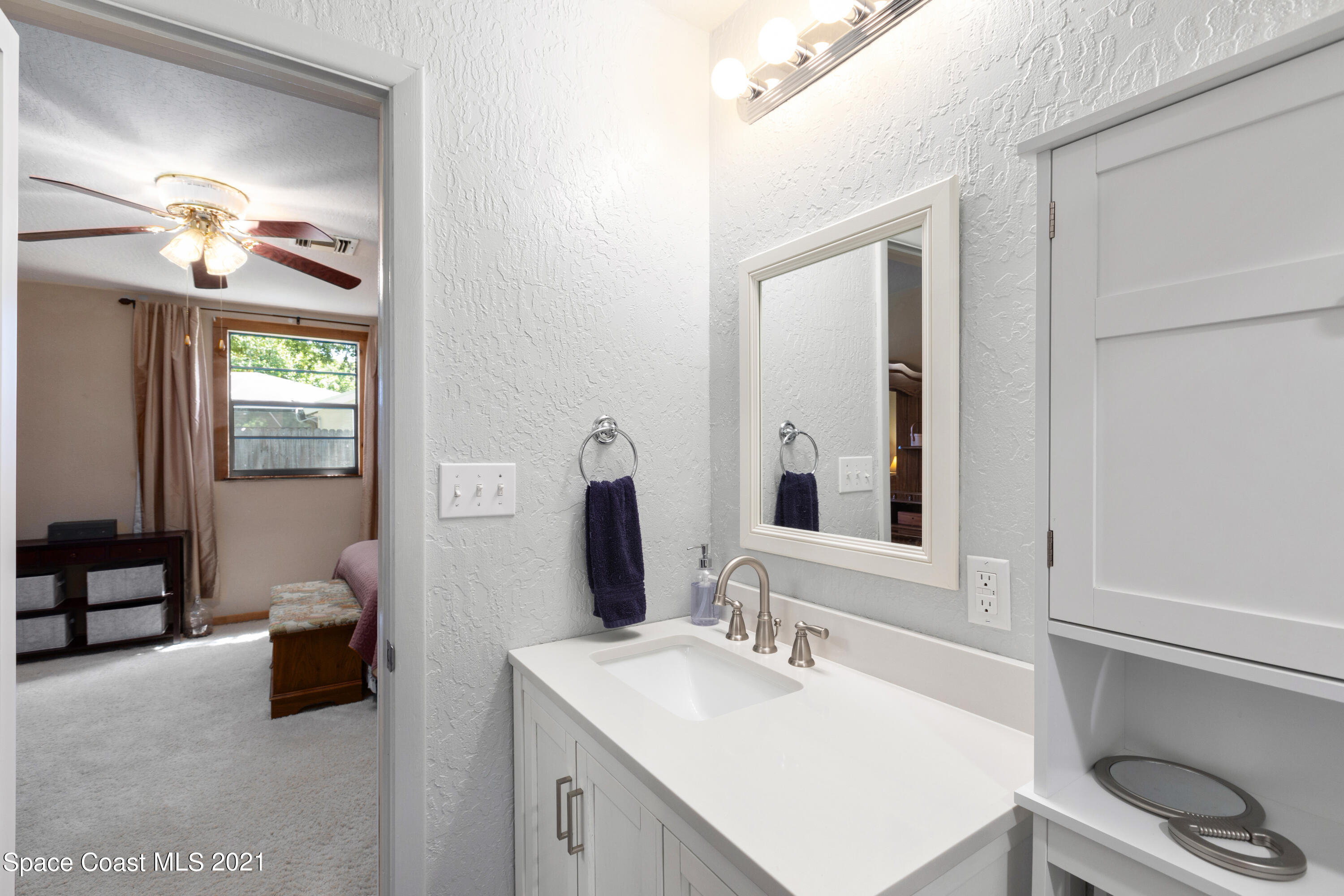 1410 Creel Road Northeast Palm Bay, FL 32905 - Photo 26 of 39 a en suite bathroom with a double vanity sink and a mirror