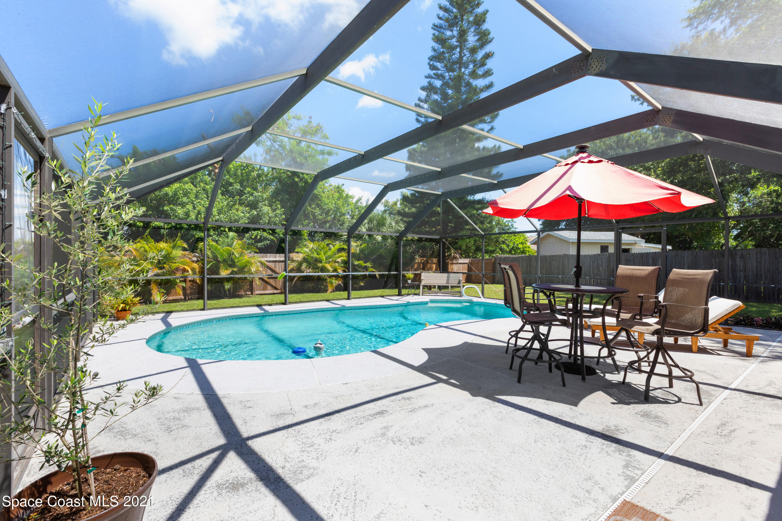 1410 Creel Road Northeast Palm Bay, FL 32905 - Photo 29 of 39 a view of a patio with a table and chairs under an umbrella