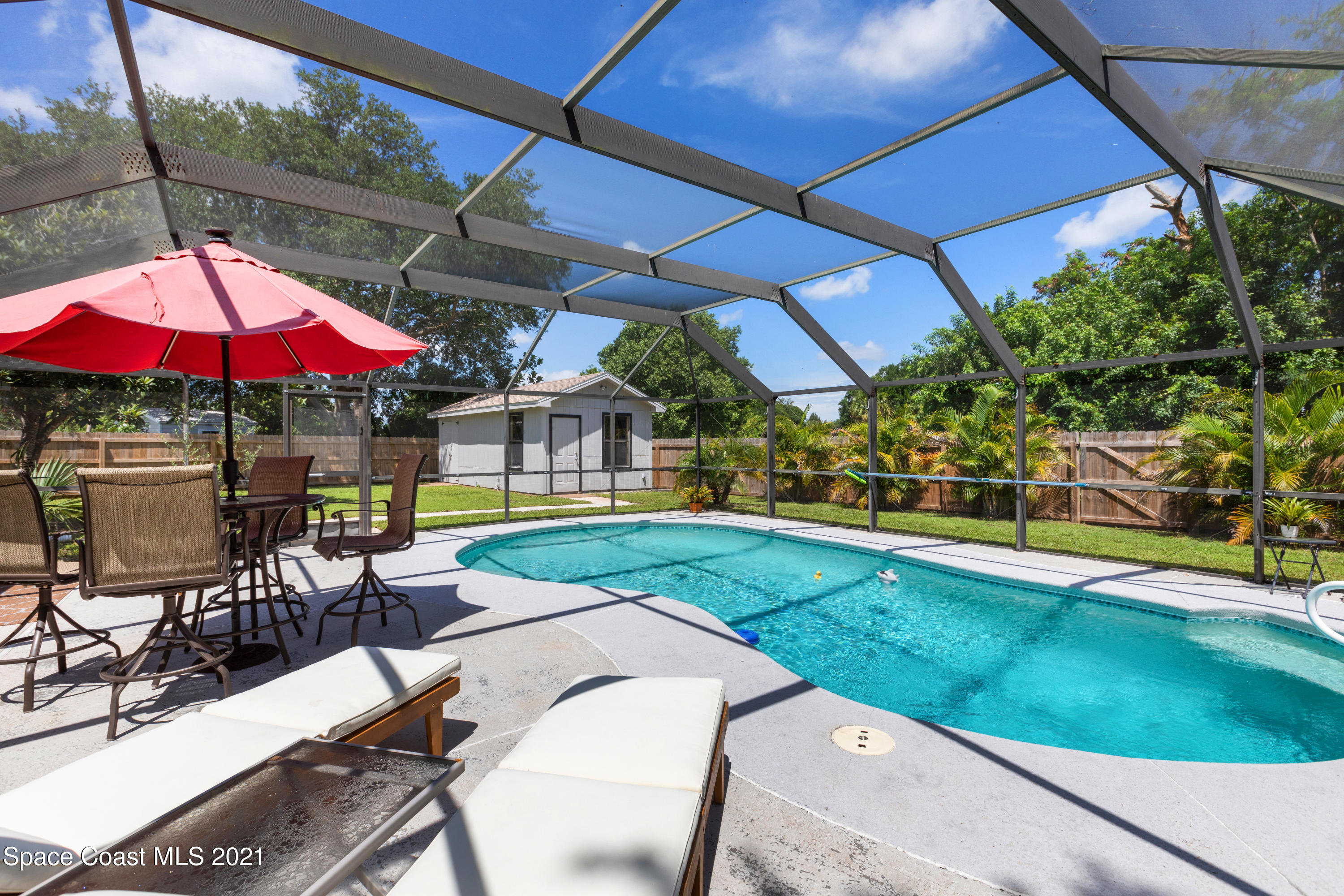 1410 Creel Road Northeast Palm Bay, FL 32905 - Photo 32 of 39 a view of a patio with a table and chairs under an umbrella