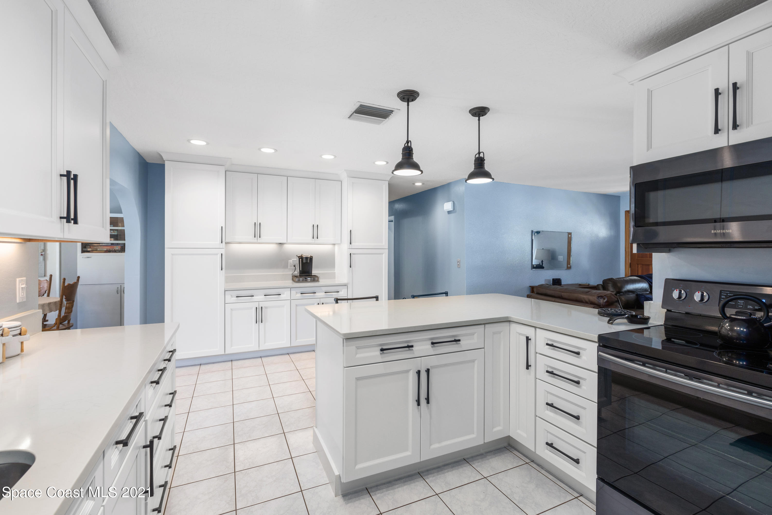 1410 Creel Road Northeast Palm Bay, FL 32905 - Photo 7 of 39 a kitchen with white cabinets and appliances