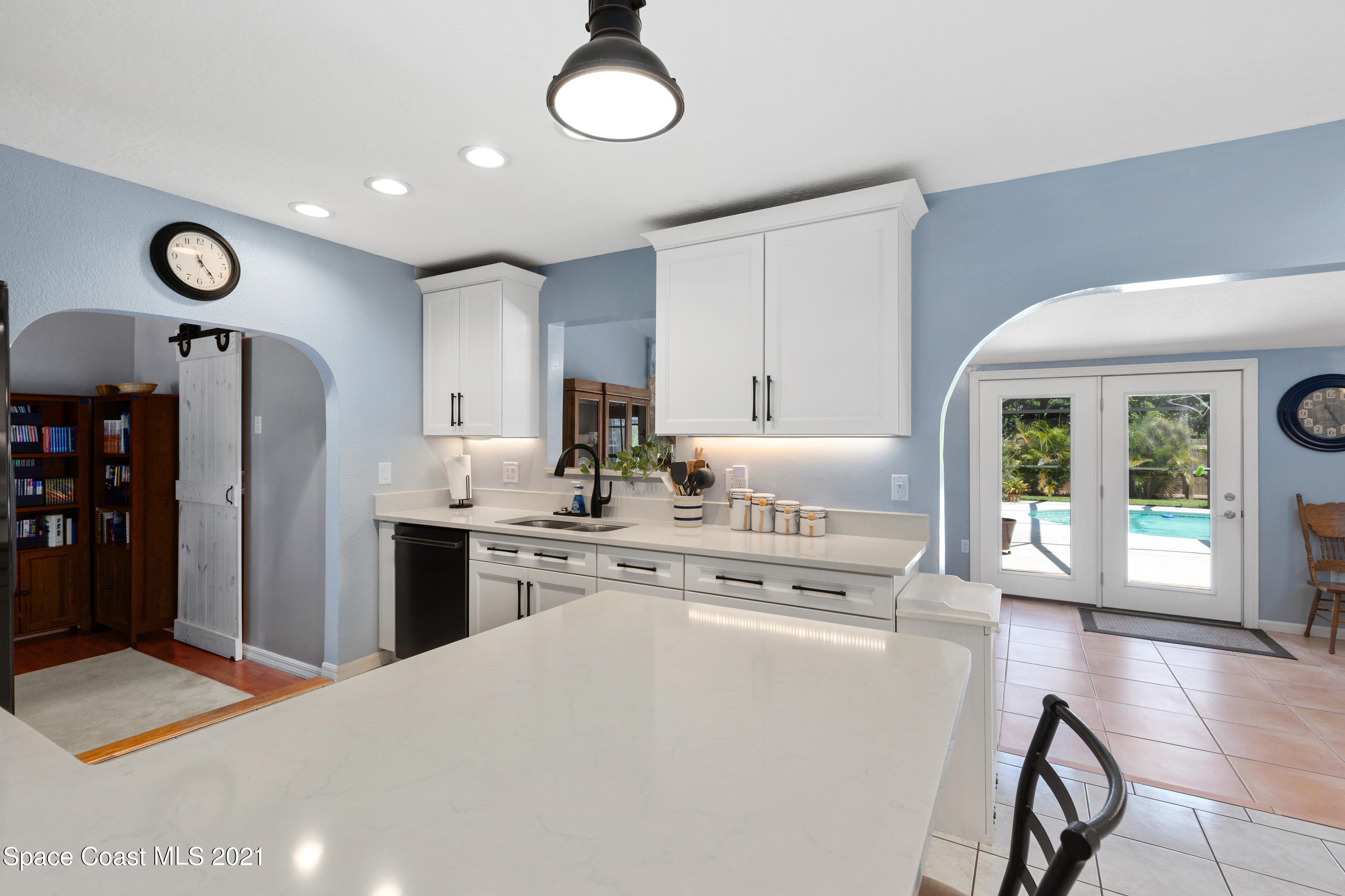 1410 Creel Road Northeast Palm Bay, FL 32905 - Photo 8 of 39 a kitchen with stainless steel appliances granite countertop a refrigerator a stove and white cabinets with wooden floor