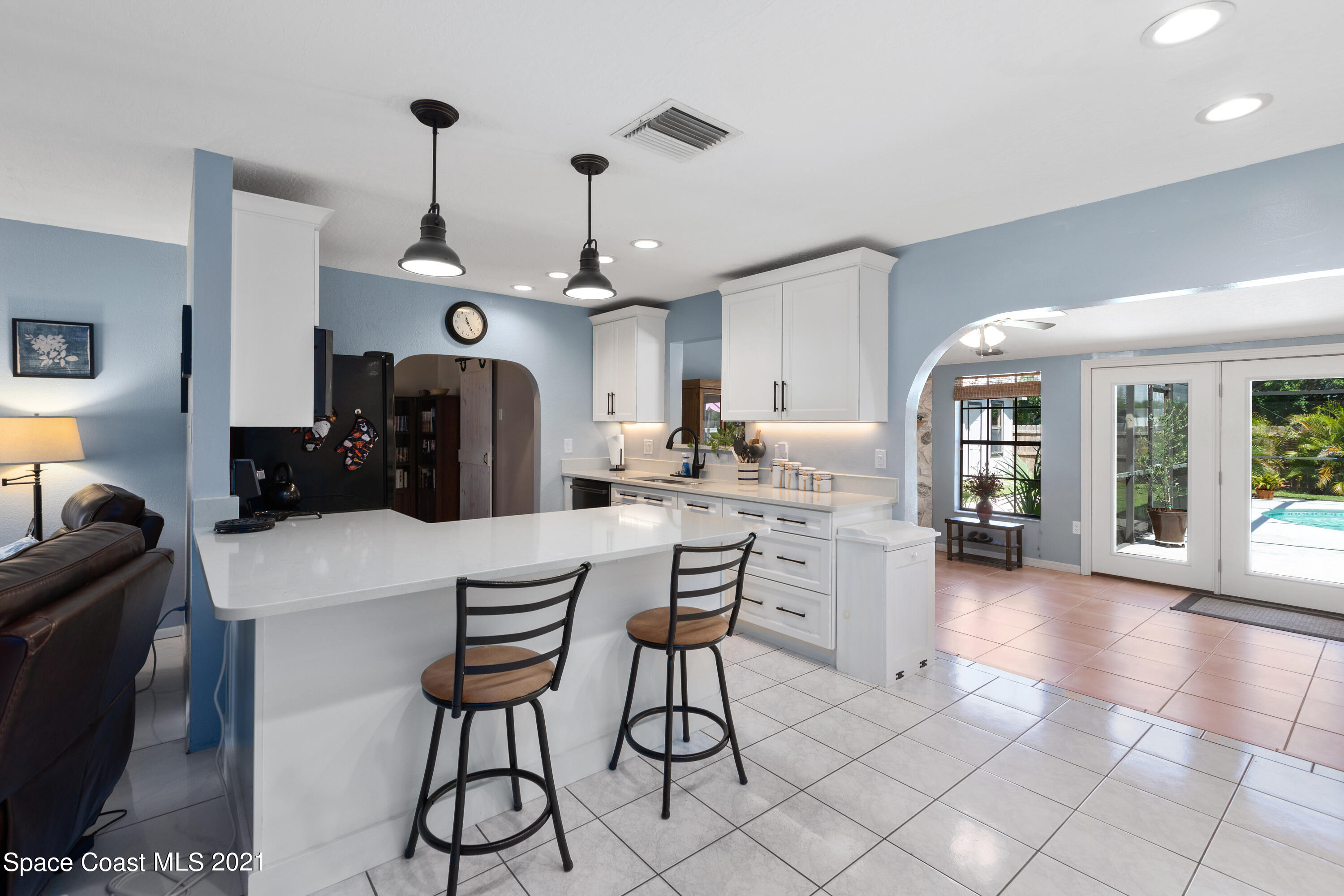 1410 Creel Road Northeast Palm Bay, FL 32905 - Photo 9 of 39 a kitchen with stainless steel appliances kitchen island granite countertop a refrigerator a stove a sink dishwasher and white cabinets with wooden floor