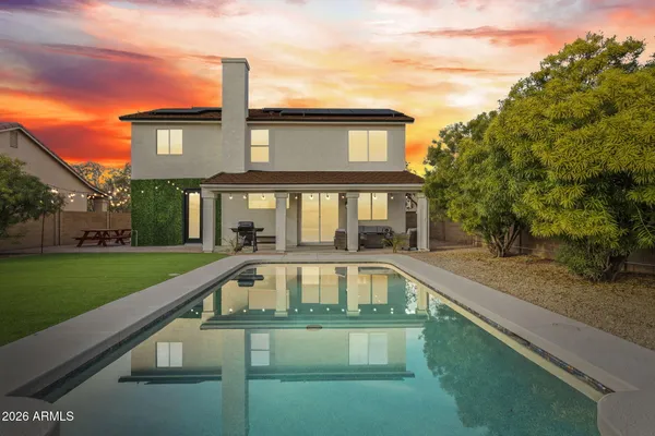 a front view of a house with swimming pool having outdoor seating