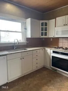 a kitchen with granite countertop white cabinets and stainless steel appliances