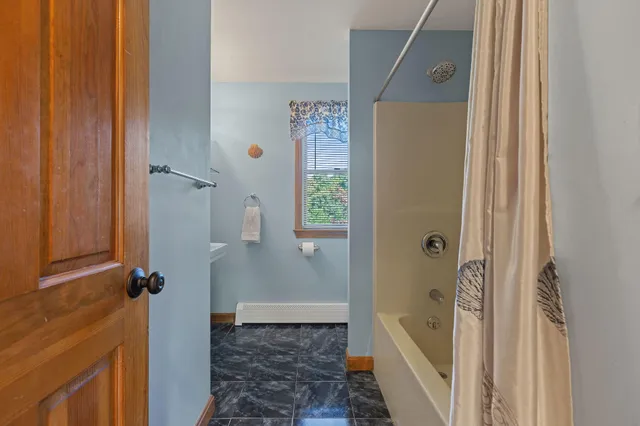 a bathroom with a tub shower and a sink