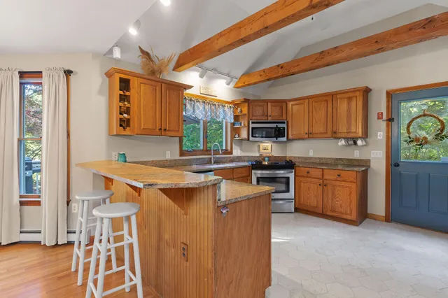 a kitchen that has a lot of cabinets in it and wooden floor