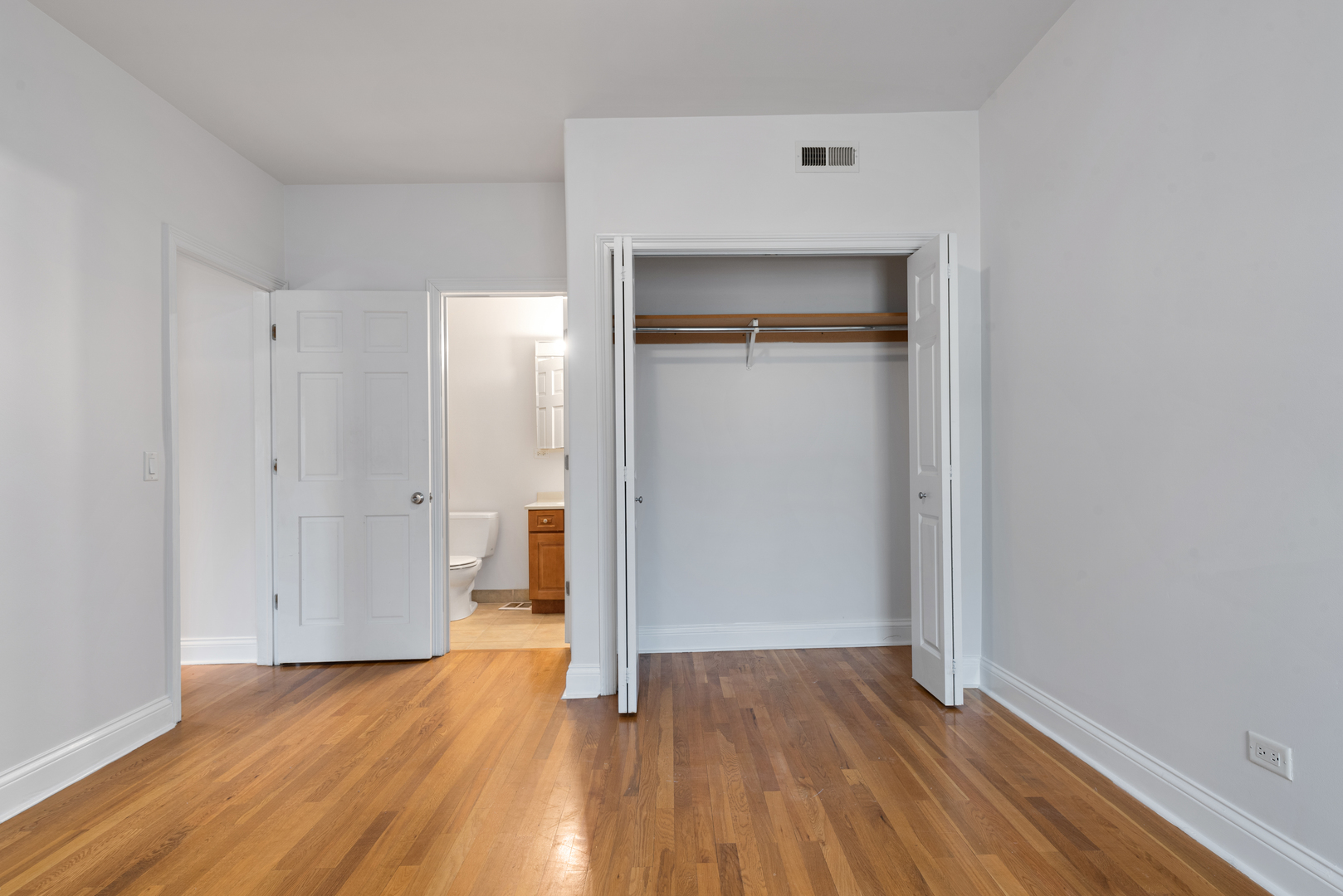 7010 South Clyde Avenue, Unit 3N Chicago, IL 60649 - Photo 11 of 19 a view of an empty room with wooden floor and a window