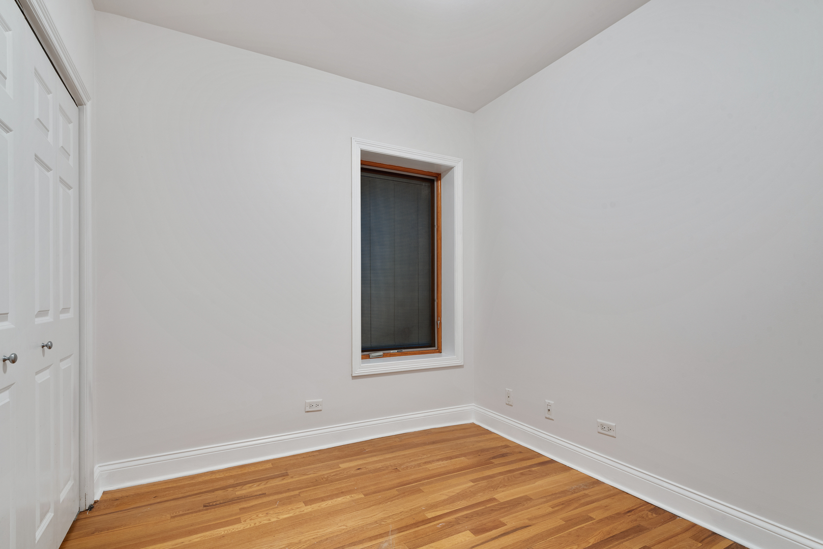 7010 South Clyde Avenue, Unit 3N Chicago, IL 60649 - Photo 5 of 19 a view of an empty room with wooden floor and a window