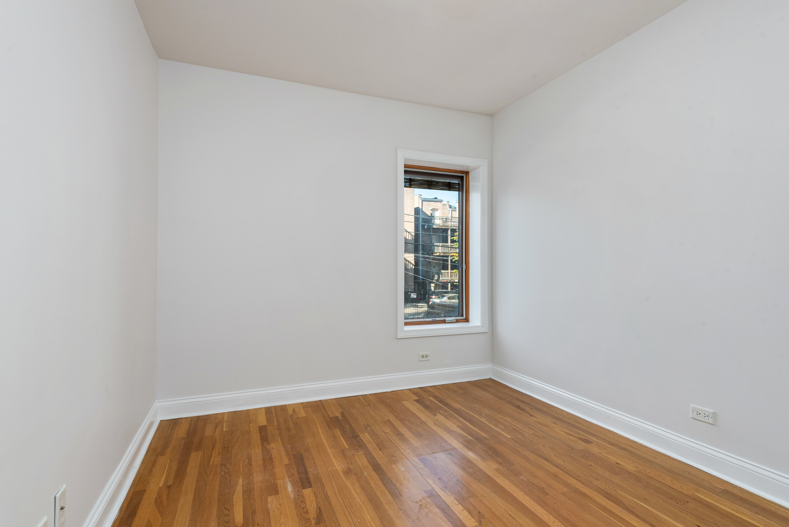 7010 South Clyde Avenue, Unit 3N Chicago, IL 60649 - Photo 8 of 19 an empty room with wooden floor and windows