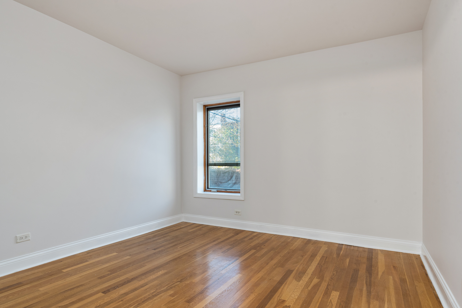 7010 South Clyde Avenue, Unit 3N Chicago, IL 60649 - Photo 10 of 19 an empty room with wooden floor and windows