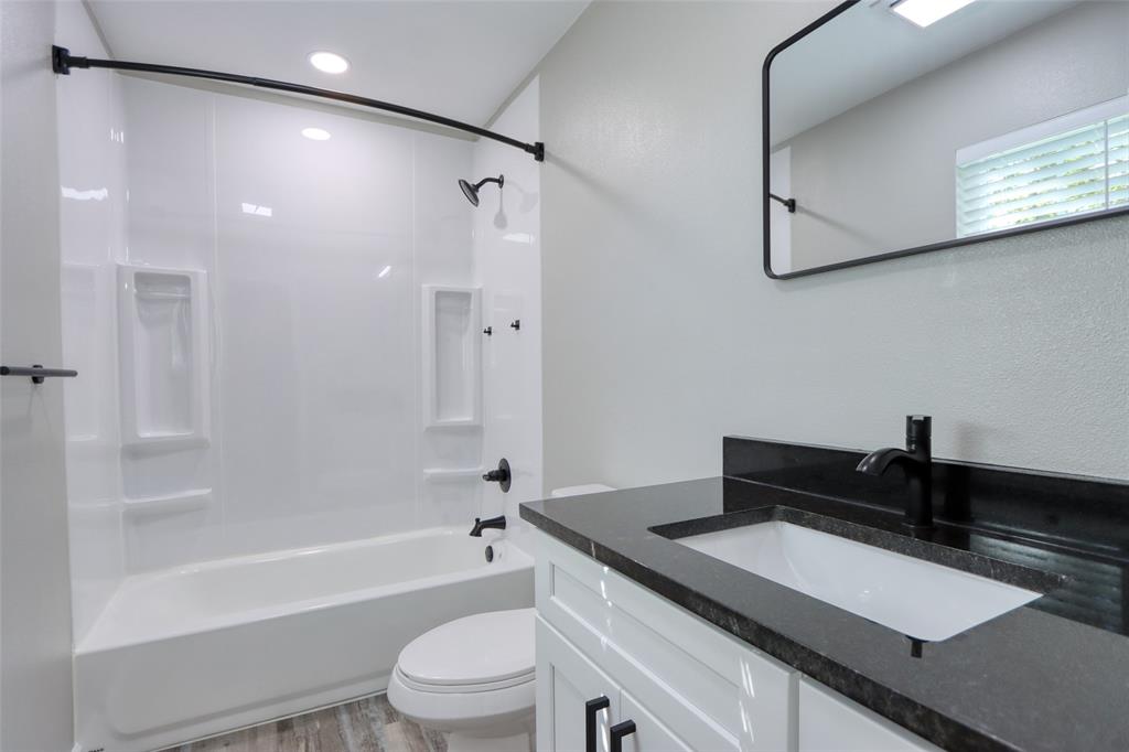 111 Kay Drive Robinson, TX 76706 - Photo 11 of 40 a bathroom with a granite countertop sink a toilet a mirror and bathtub