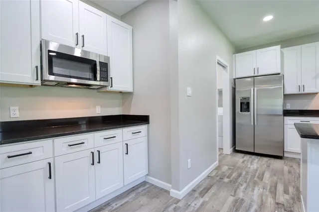 a kitchen with stainless steel appliances a microwave a sink and cabinets