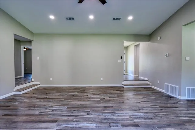 a view of an empty room with wooden floor