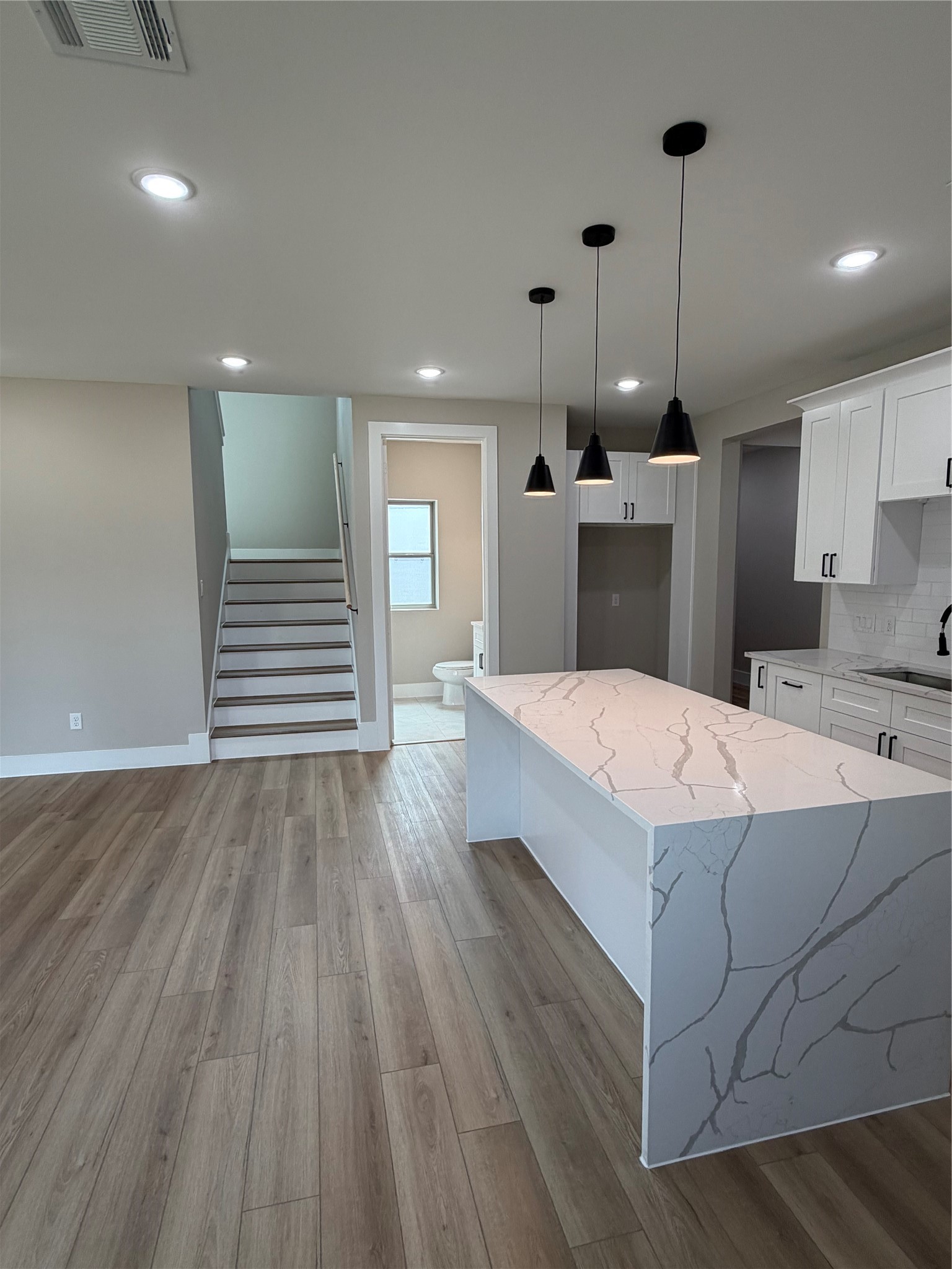 2514 Liguria Lane Spring, TX 77388 - Photo 20 of 25 a large white kitchen with wooden floors and a fireplace