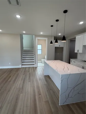 a large white kitchen with wooden floors and a fireplace