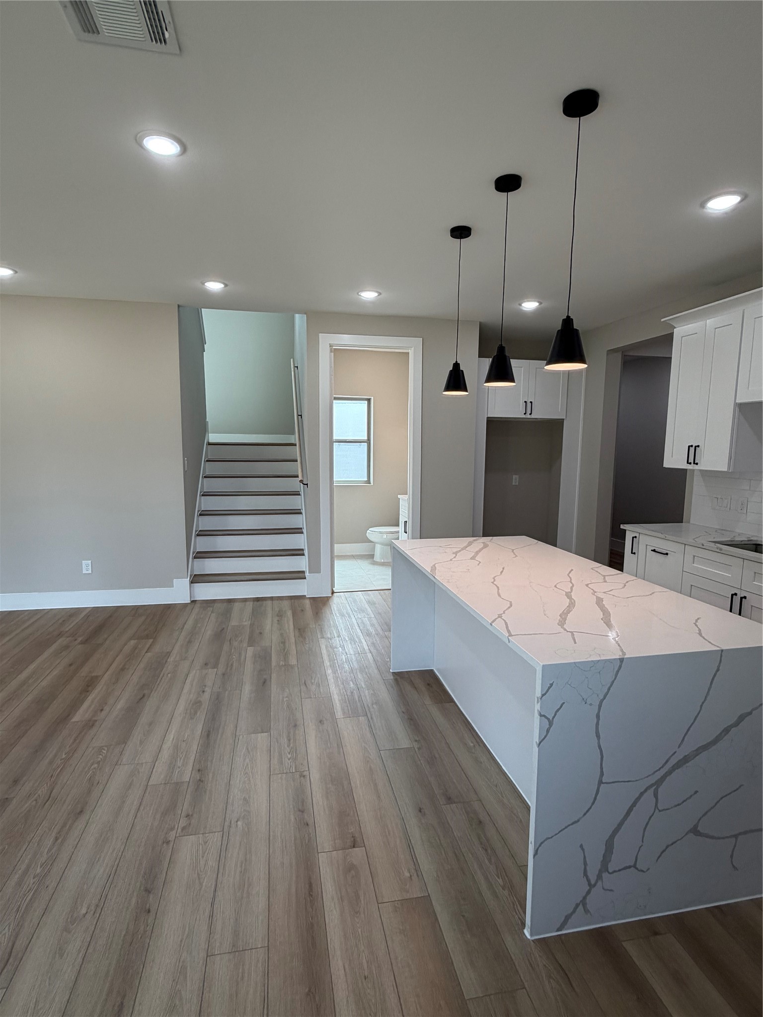 2514 Liguria Lane Spring, TX 77388 - Photo 21 of 25 a large white kitchen with wooden floors and a fireplace
