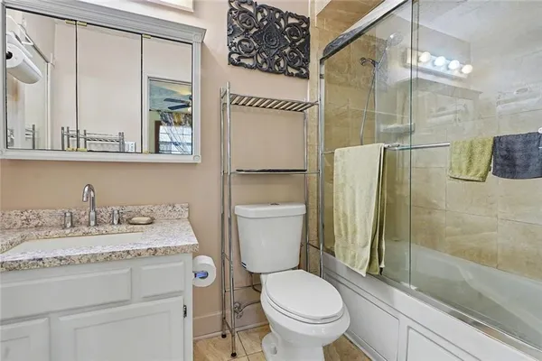 a bathroom with a granite countertop sink toilet and shower