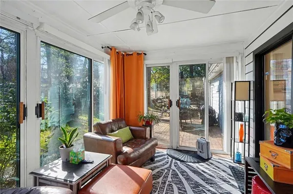 a living room with patio furniture and a potted plant