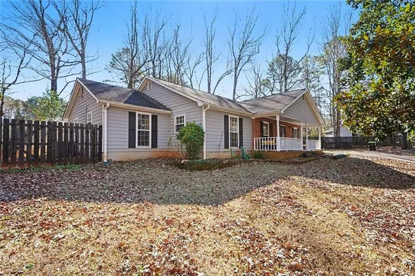 a view of a yard with a house and wooden fence