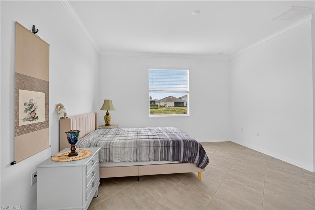 2126 Hamlin Street Naples, FL 34120 - Photo 11 of 38 a bedroom with a bed and a table in it