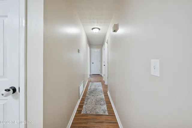 a view of a hallway with wooden floor