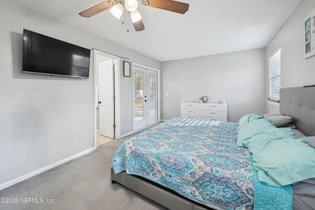 a bedroom with a large bed and a flat screen tv