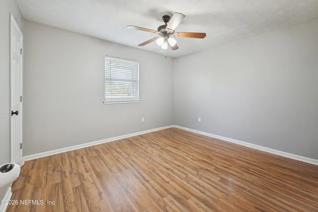wooden floor in an empty room with a window