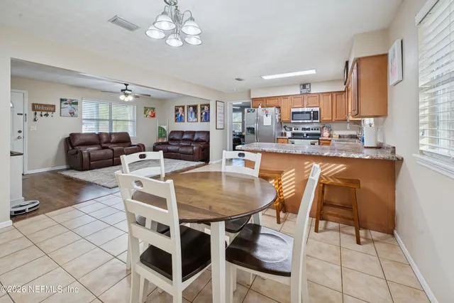 a living room with furniture a chandelier and a dining table