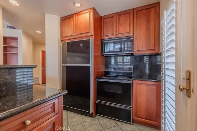 a kitchen with granite countertop stainless steel appliances and wooden cabinets