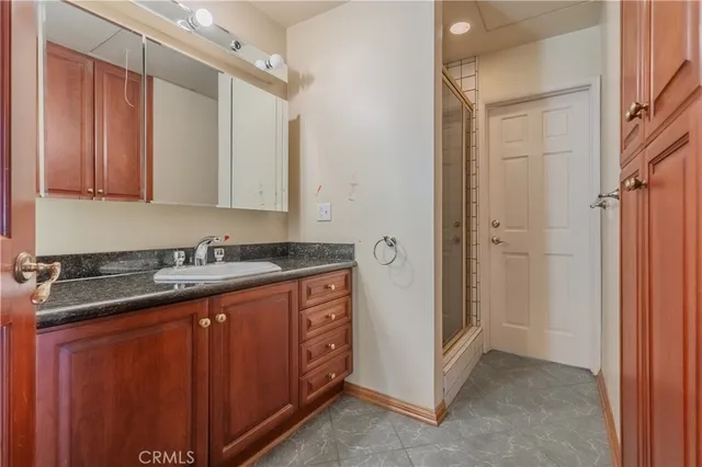 a bathroom with a granite countertop sink and a mirror